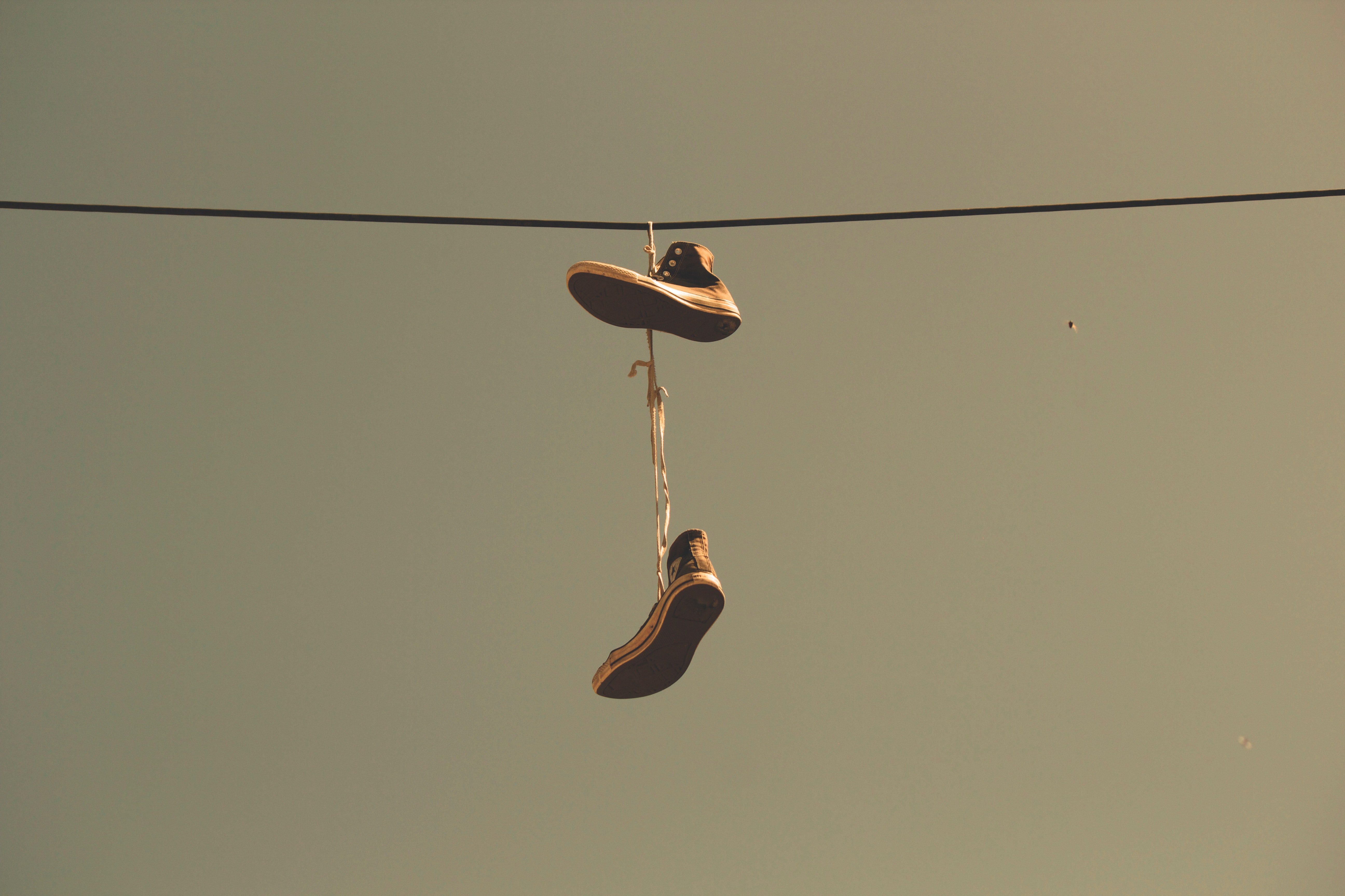 Twee sneakers hangen aan een kabel in de lucht