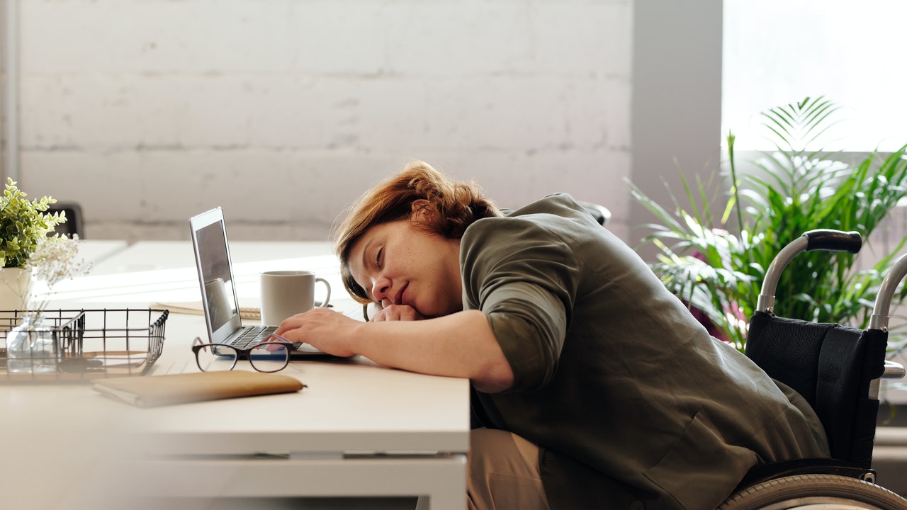Vrouw is in slaap gevallen op haar bureau op het werk