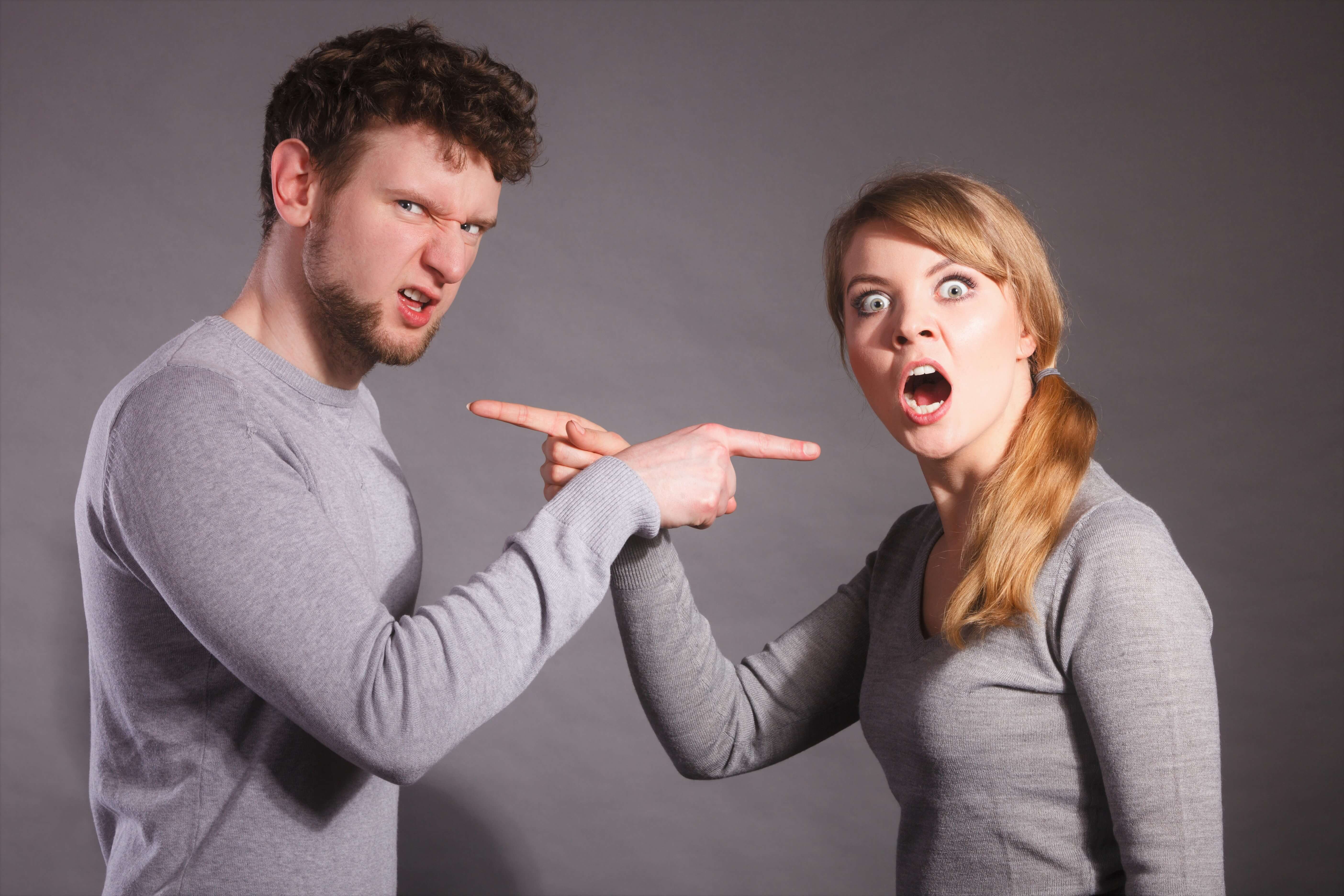 Man en vrouw wijzen beschuldigend naar elkaar