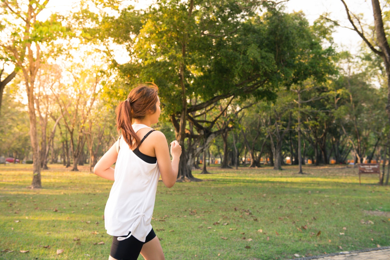 Jogger in wit shirt in zonnig park