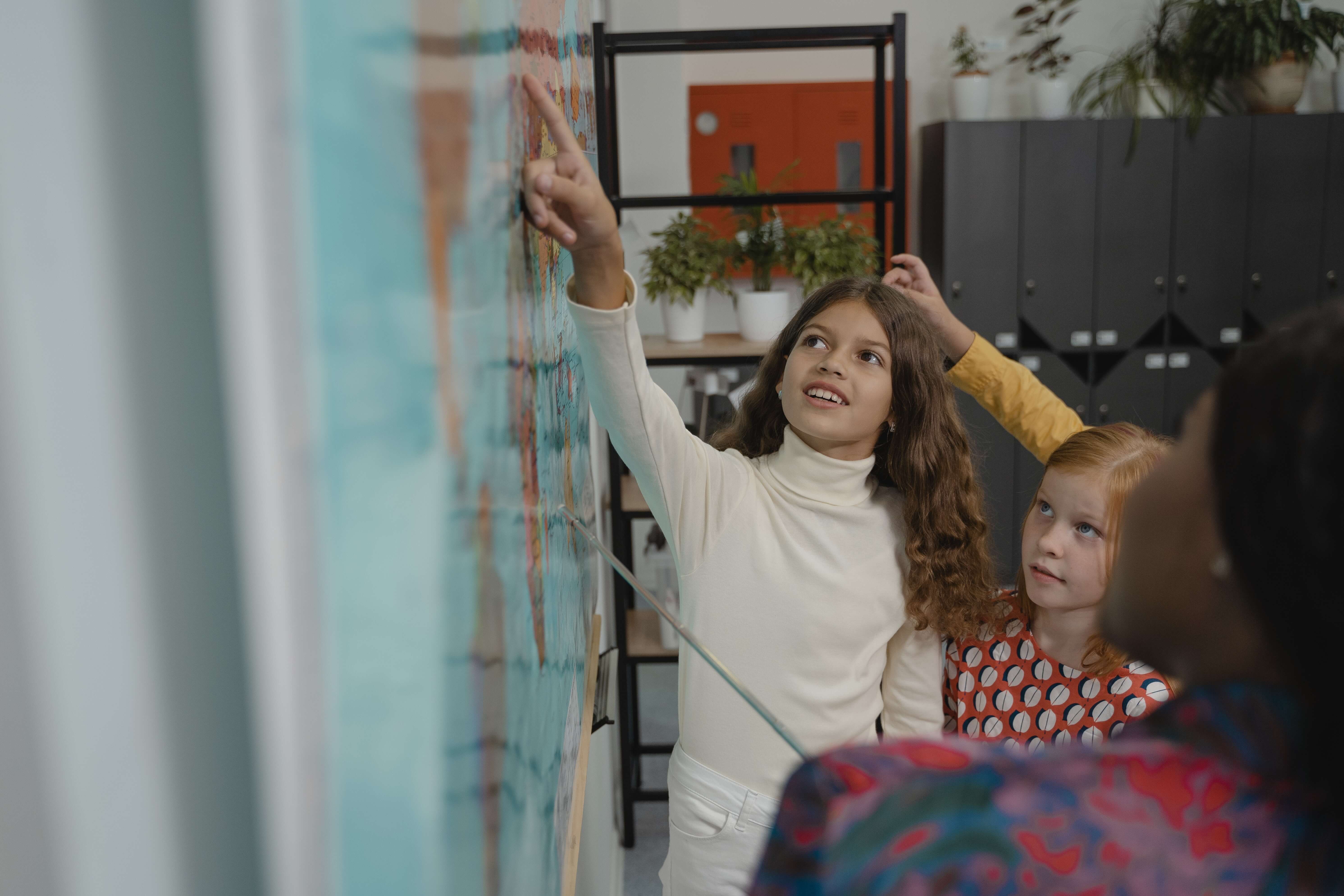 Leerlingen wijzen landen aan op wereldkaart in de klas