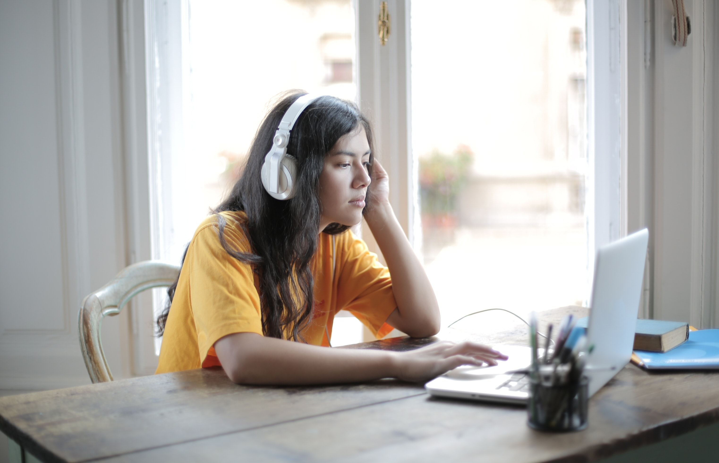 Jongedame in geel shirt aan laptop