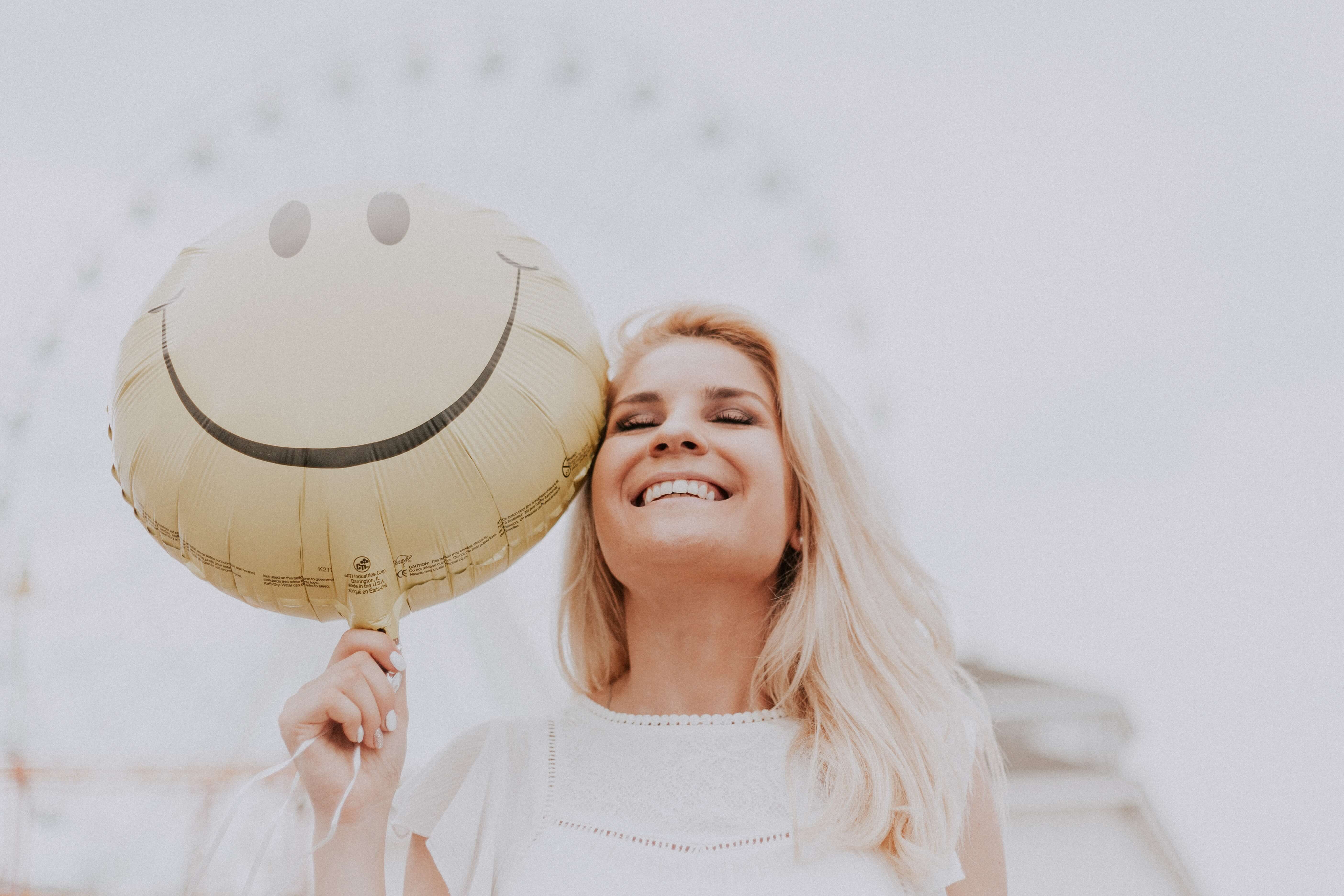 Lachende vrouw met smileyballon