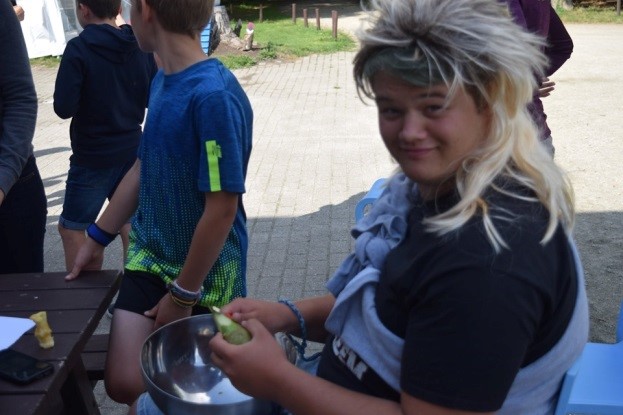 Begeleider Matthias met blonde pruik tussen de kinderen