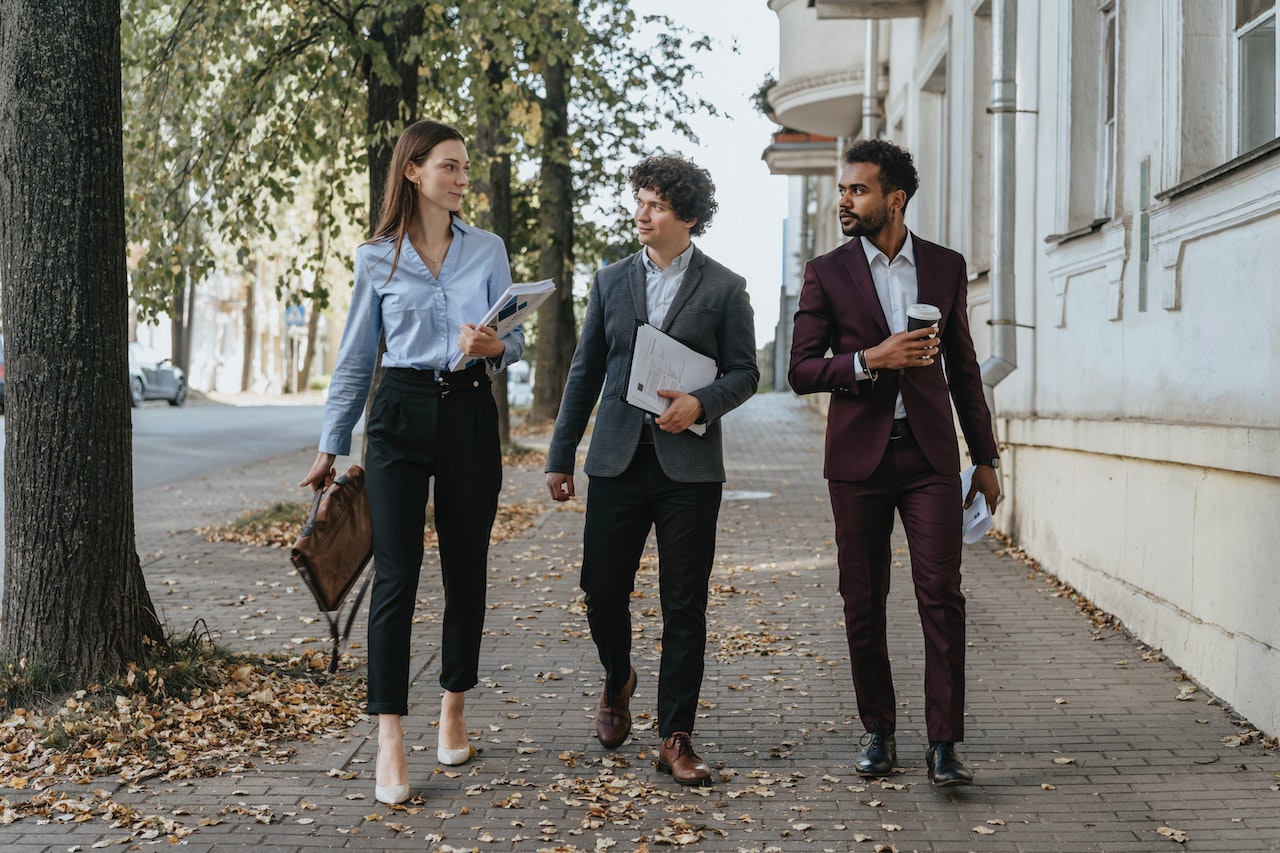 Drie stagiairs of werknemers wandelen samen op straat