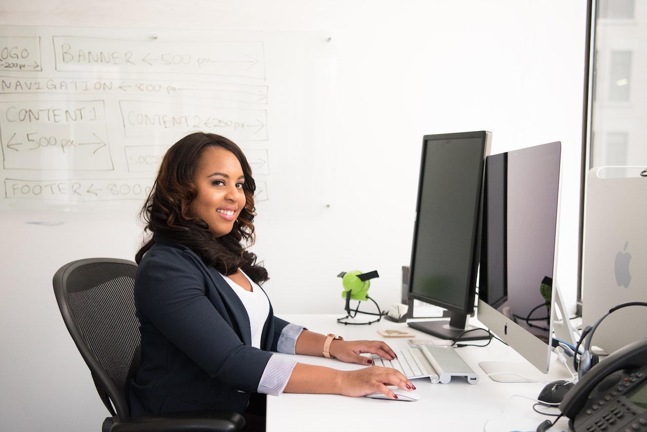 Lachende stagiaire aan bureau